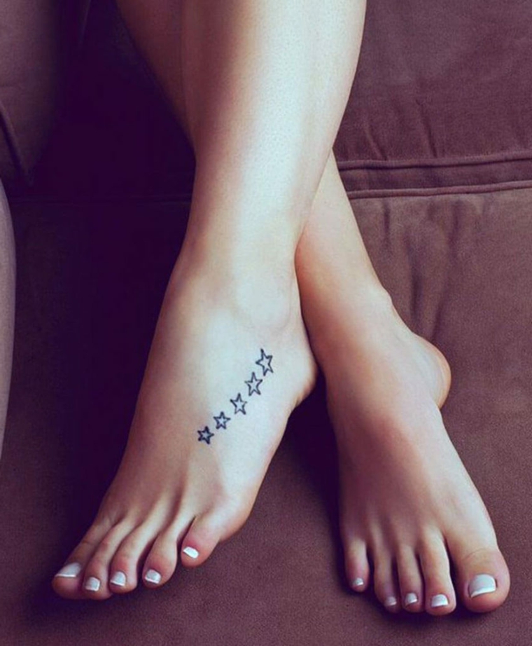 Stelline tattoo piccole sulla caviglia di una donna, pedicure con smalto bianco