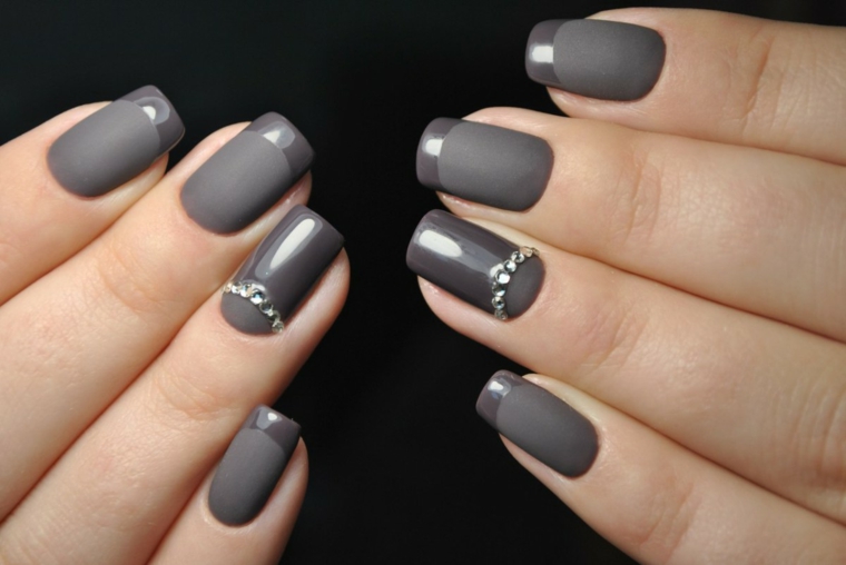 Una french manicure particolare smalto grigio lucido su una base opaca e decorazioni con brillantini 