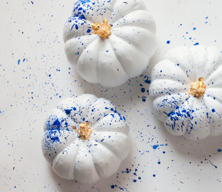 Zucche di Halloween di colore bianco decorate con schizzi di vernice blu
