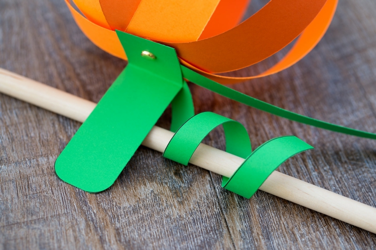 Cartoncino verde avvolto su un bastoncino di legno per creare un effetto riccio