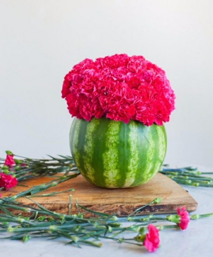 Idee lavoro fai da te con un cocomero intagliato e privato della polpa da essere utilizzato come vaso per fiori