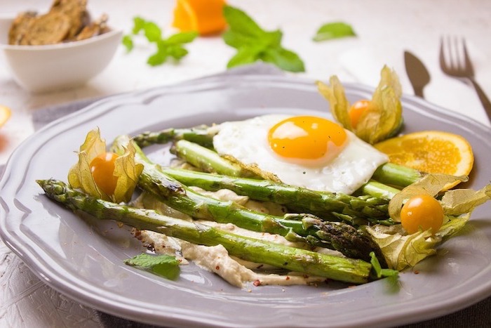 Un'idea per alimentazione sana ed equilibrata con un piatto di asparagi e uovo in camicia