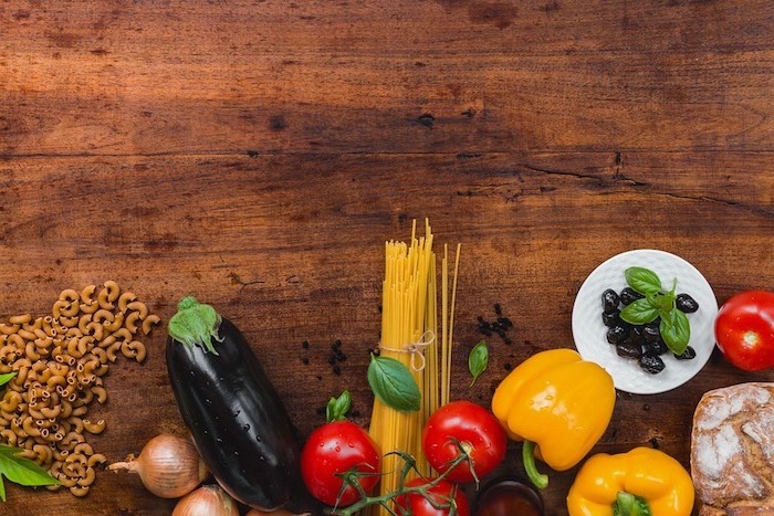 Ingredienti per un'alimentazione corretta, tavolo di legno verdure colorate e spaghetti 