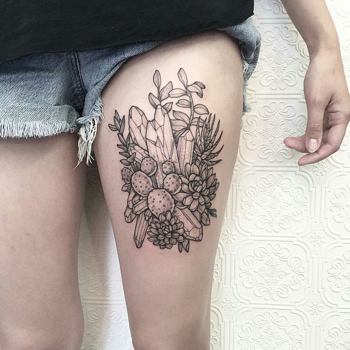 Ragazza con un grande tattoo sulla coscia con fiori e forme geometriche