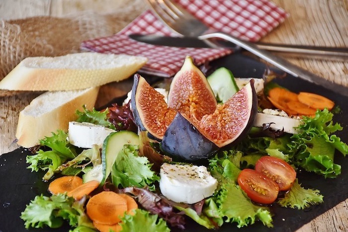 Alimentazione sana e un'idea con piatto di insalata verde con fichi e pomodorini 