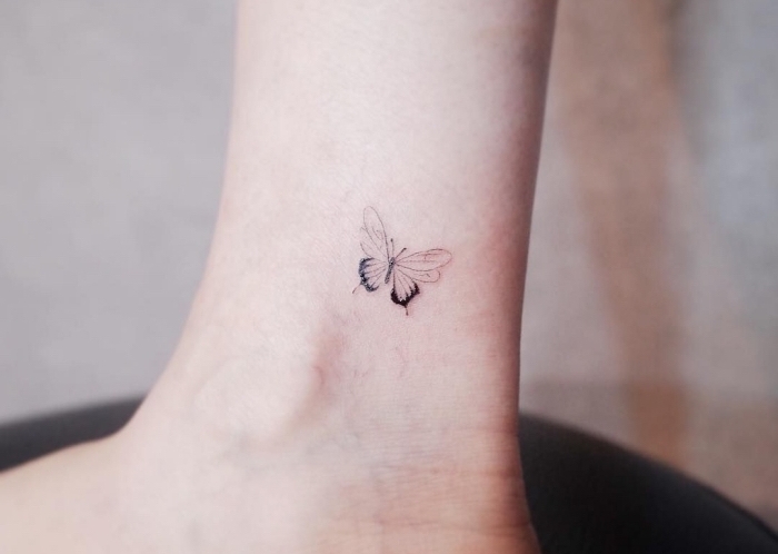 Tattoo femminili e il disegno di una farfalla sulla caviglia di una donna