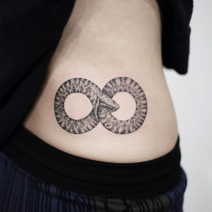 Geometric tattoo con il simbolo dell'infinito di un serpente che morde sul corpo di una ragazza