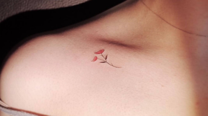 Tatuaggi discreti e un'idea con un tattoo di fiore colorato sulla clavicola di una donna