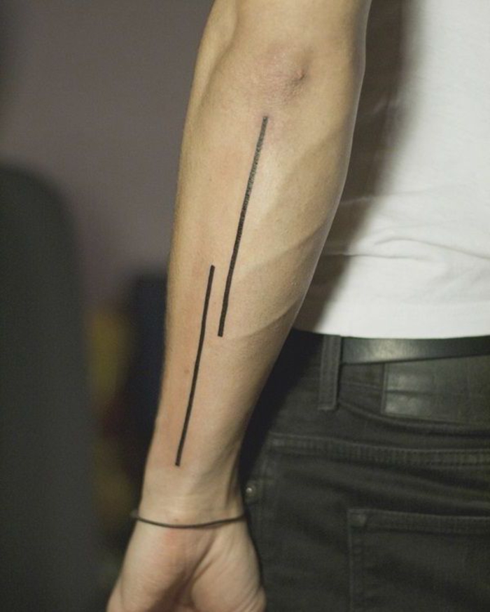 Il braccio di un uomo con un tattoo di due linee, idea per un tatuaggio maschile 