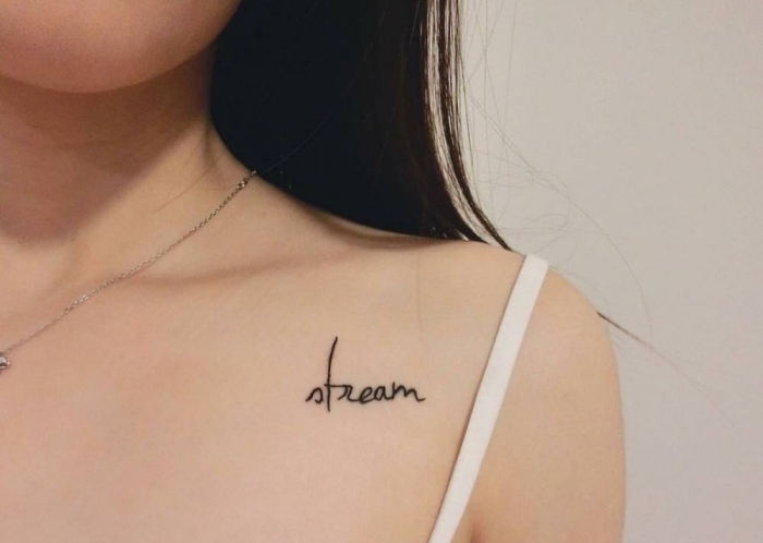 Tatuaggi piccoli particolari femminili e un'idea con scritta sulla clavicola di una donna