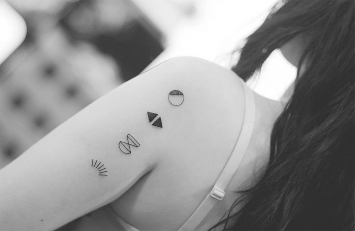 Idee per dei tatuaggi piccoli e una proposta con dei simboli sul braccio di una donna
