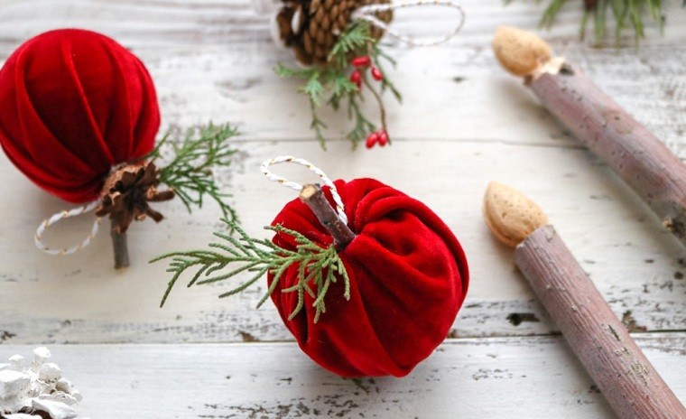 Addobbi natalizi fatti a mano con palline e pezzettini di legno, decorazione con rametti e bacche rosse