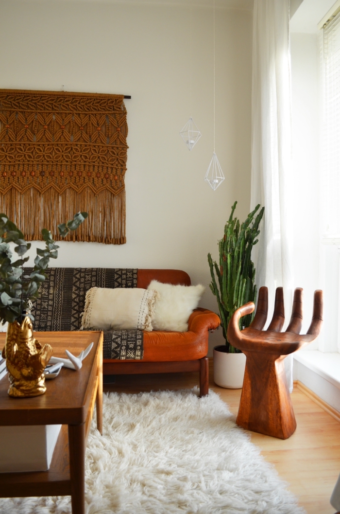 Un soggiorno arredato in stile rétro e decorato con un macramè di colore marrone