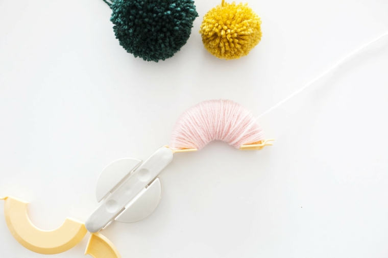 Lavoretti creativi Natale, un aggeggio di plastica per creare pon pon di lana 