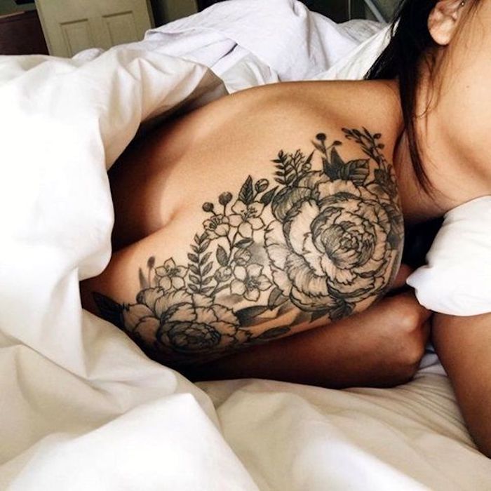 Idea per dei tatuaggi femminili con fiori sulla spalla di una donna