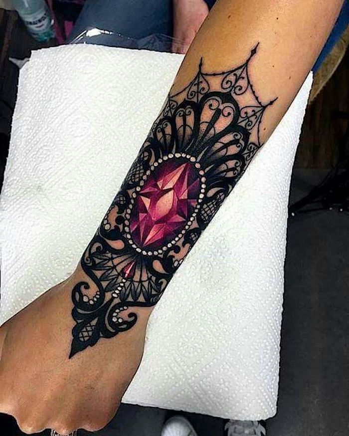 Tattoo mandala sull'avambraccio di una donna con diamante rosa 