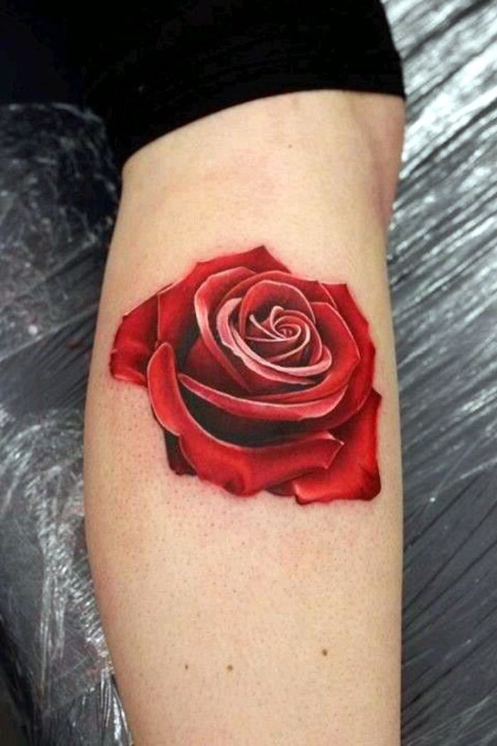 Rosa di colore rosso come tatuaggio sulla gamba di una donna