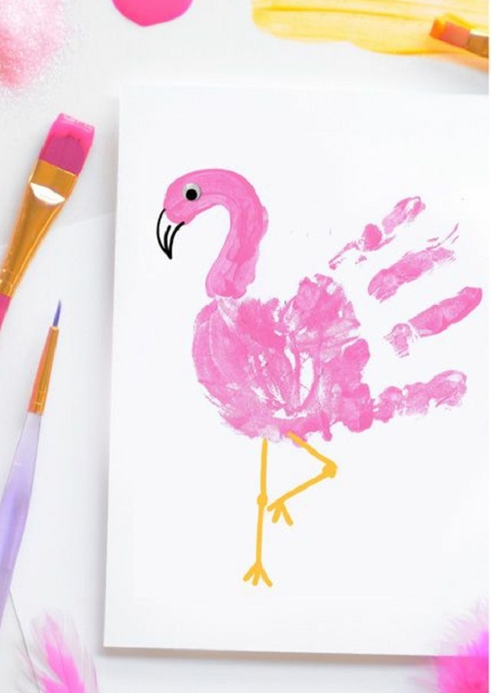 Un disegno con impronta rosa della manina di un bambino a forma di flamingo rosa