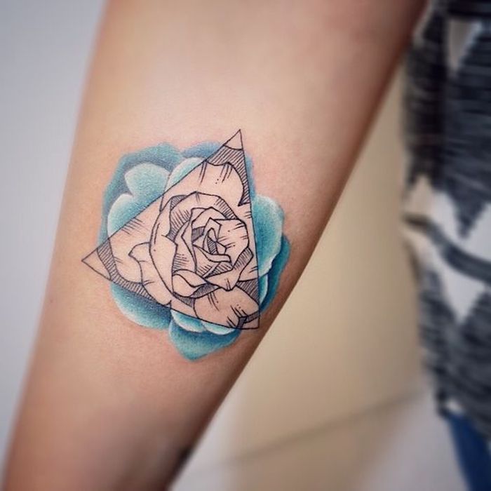 Triangolo con una rosa all'interno come tatuaggio sull'avambraccio di una donna