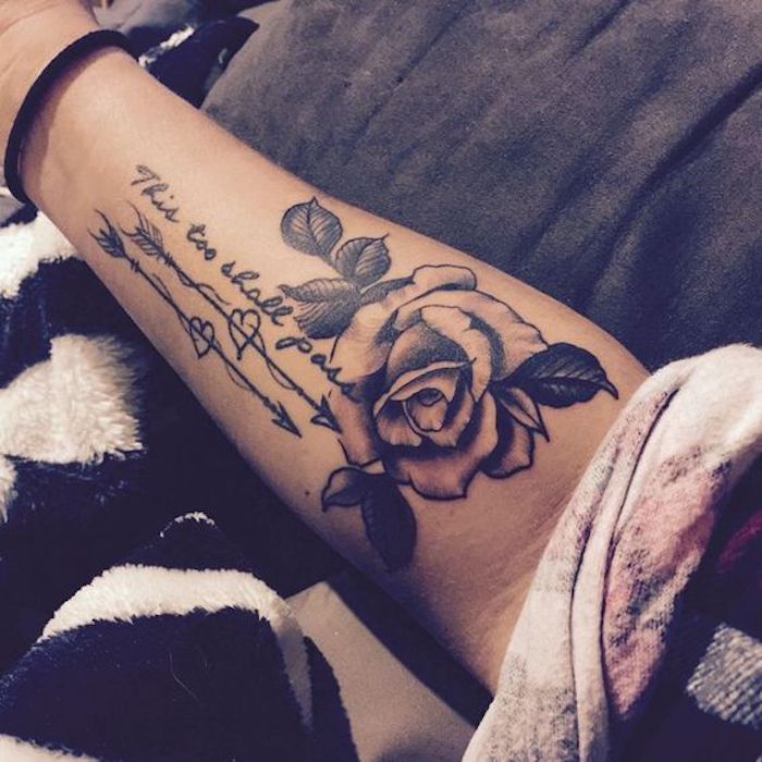 L'avambraccio di una donna con un tatuaggio di rosa e scritta in inglese