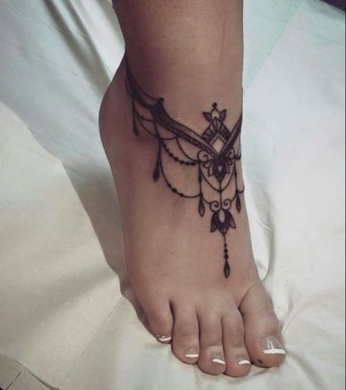 Simboli tatto motivi mandala come tatuaggio sul piede di una donna