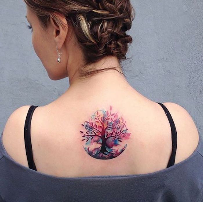 Tattoo simboli e uno con albero colorato sulla schiena di una donna