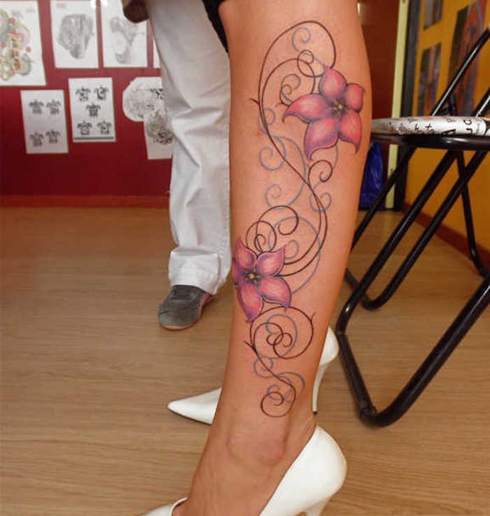 La gamba di una donna con tattoo motivi floreali dai petali rosa