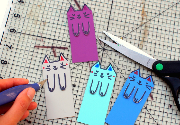Lavoretti creativi come dei segnalibro di cartoncini colorati a forma di gattini con zampe