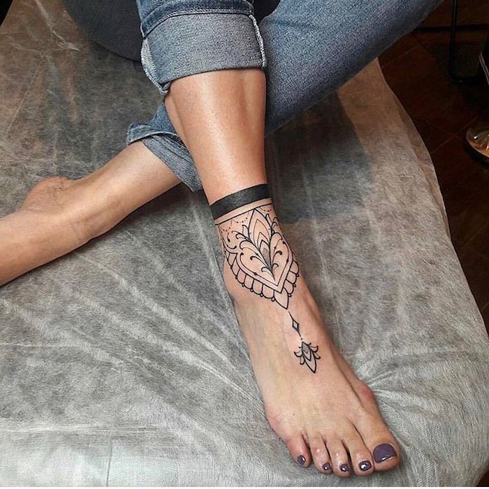 Il piede di una donna tatuato con simbolo mandala effetto bracciale