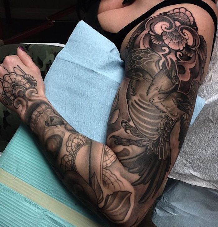 Tatuaggi braccio donne, una donna con grande tattoo di un uccello e motivi floreali
