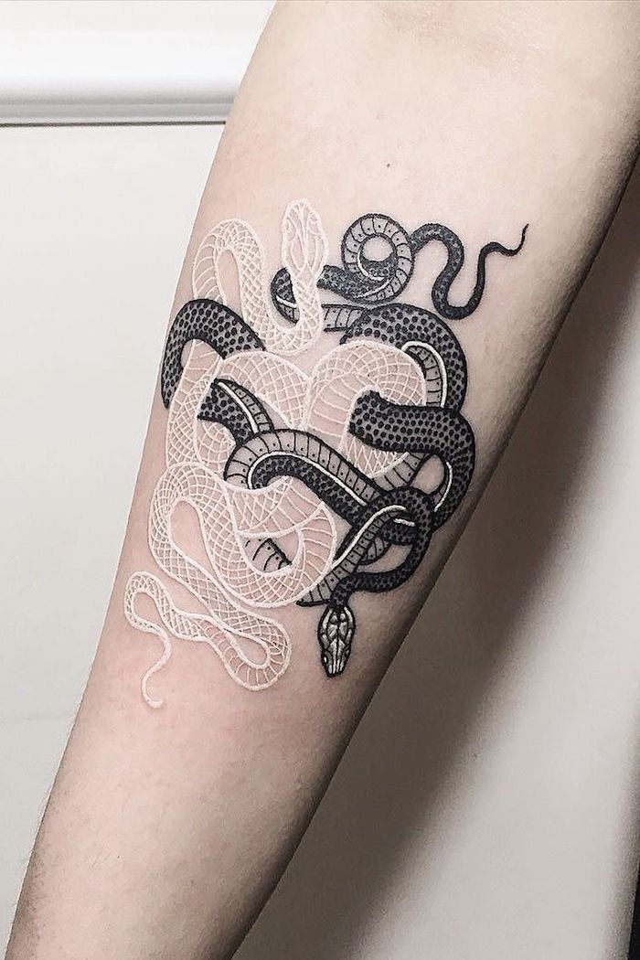 Tatuaggio bianco e nero con serpenti sul braccio di una donna