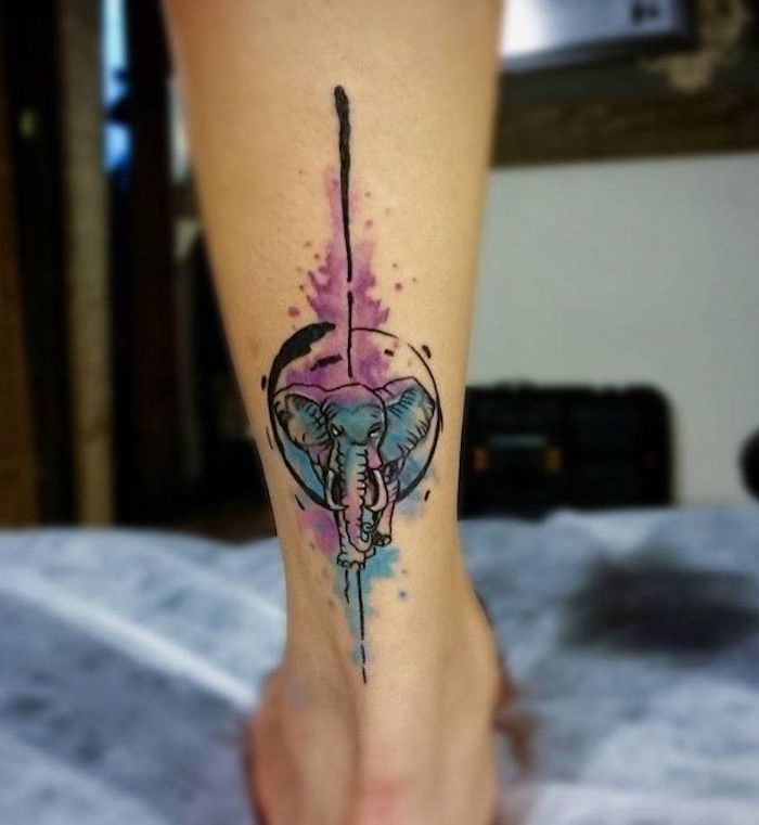 Il disegno colorato di un piccolo elefante come tatuaggio sulla gamba di una donna
