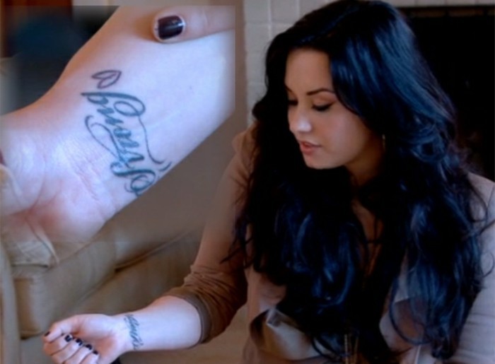 Simboli tatauggi, tattoo con scritta sul polso della mano, la cantante Demi Lovato