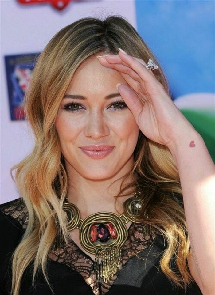 La cantante Hilary Duff, frasi da tatuarsi, tatuaggio cuore rosso, tattoo sul polso della mano