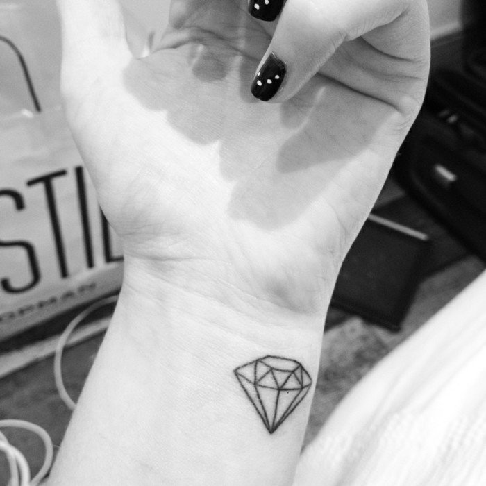 Tatuaggio diamante sul braccio, tattoo polso della mano, ragazza con smalto nero