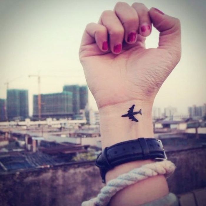 Tatuaggio con disegno aereo, polso della mano tatuato