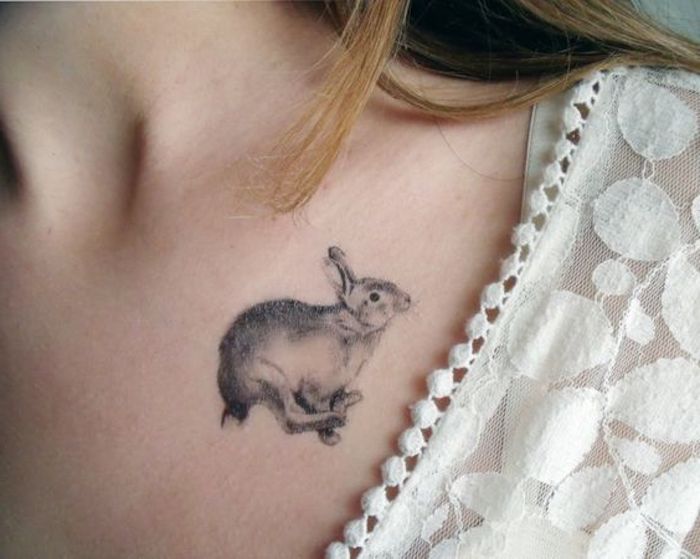 Donna con maglietta bianca, tatuaggi piccoli particolari femminili, tattoo di un coniglio