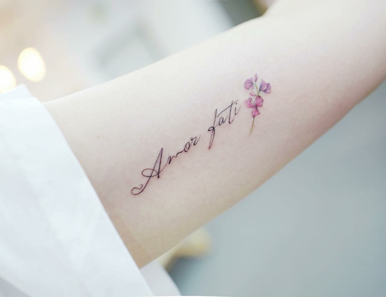 Tatuaggi scritte, tattoo sull'avambraccio, frase in latino con fiori 
