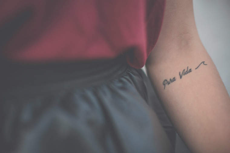 Frasi belle in spagnolo, tatuaggio sull'avambraccio, scritta Pura Vida 