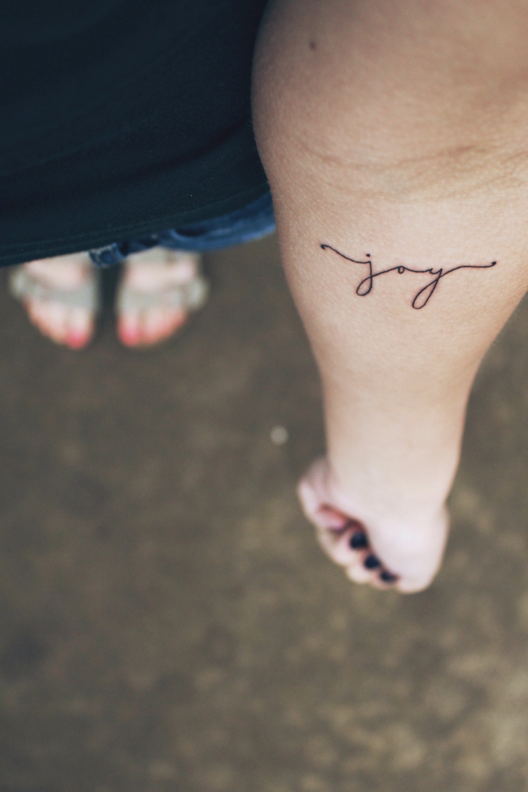 Scritta joy sull'avambraccio, tatuaggi piccoli scritte