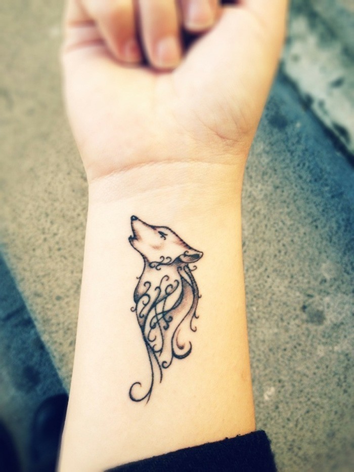Simboli tatuaggi per donna, disegno di un lupo, tattoo sul polso della mano