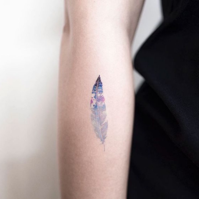 Tattoo piuma sull'avambraccio, donna tatuata, tattoo schiena donne