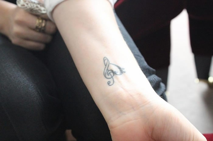 Idea tatuaggio polso, tattoo con cuore e nota musicale, braccio di una donna