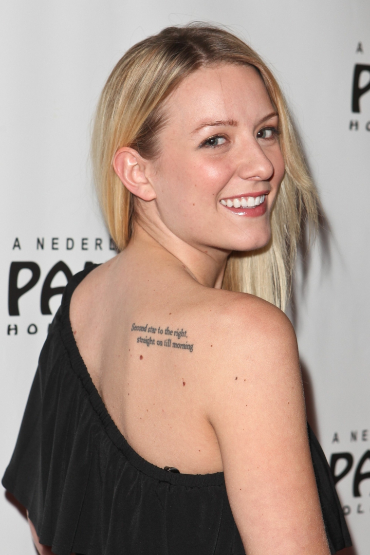 Donna con capelli biondi, tatuaggio dedicato alla famiglia, tattoo sulla schiena, tatuaggio con scritta 