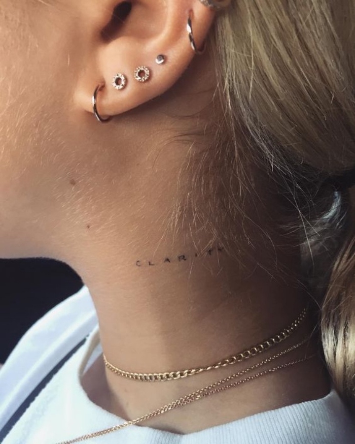 Tatuaggi femminili eleganti, scritta sul collo, ragazza con tanti orecchini