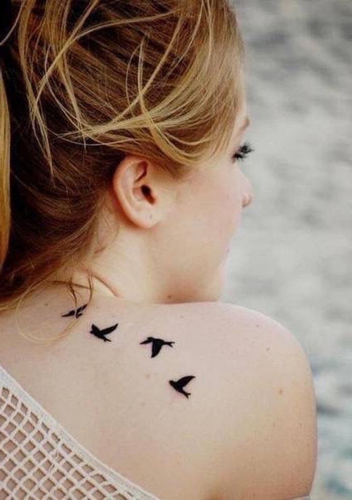 Donna con tatuaggio sulla schiena, tattoo uccelli che volano