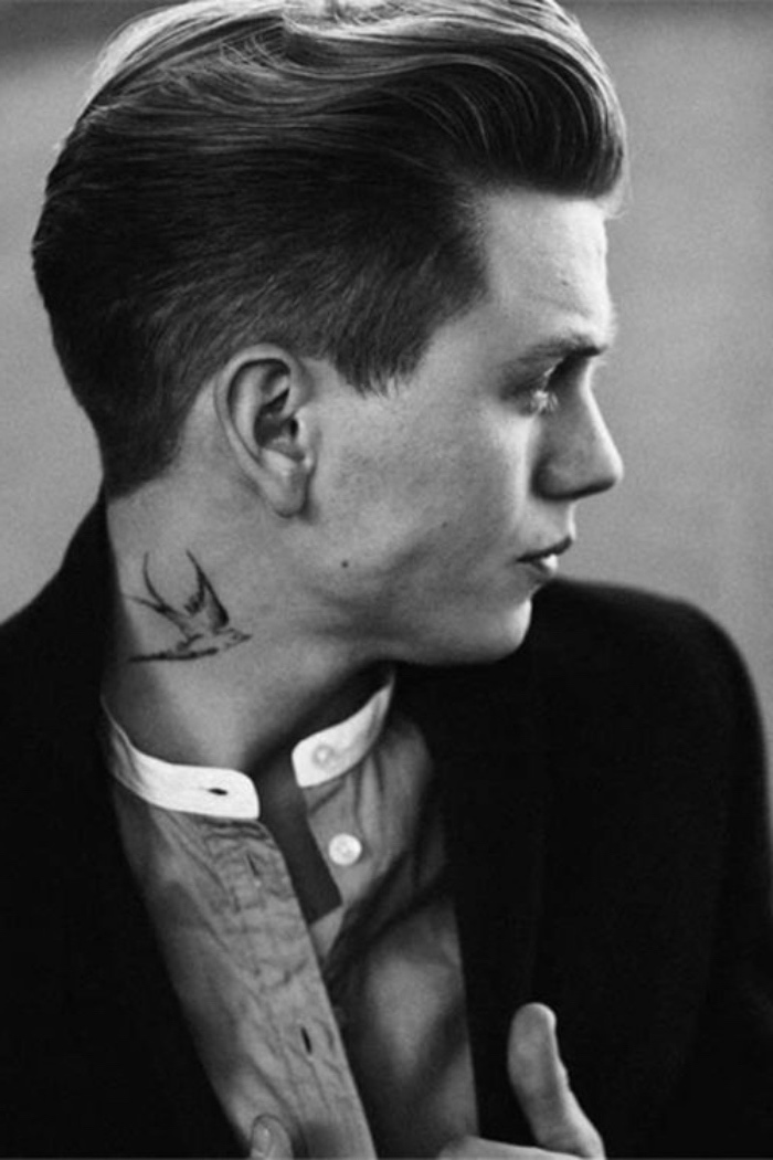 Uomo con tatuaggio sul collo, tattoo uccello, capelli biondi tirati indietro 