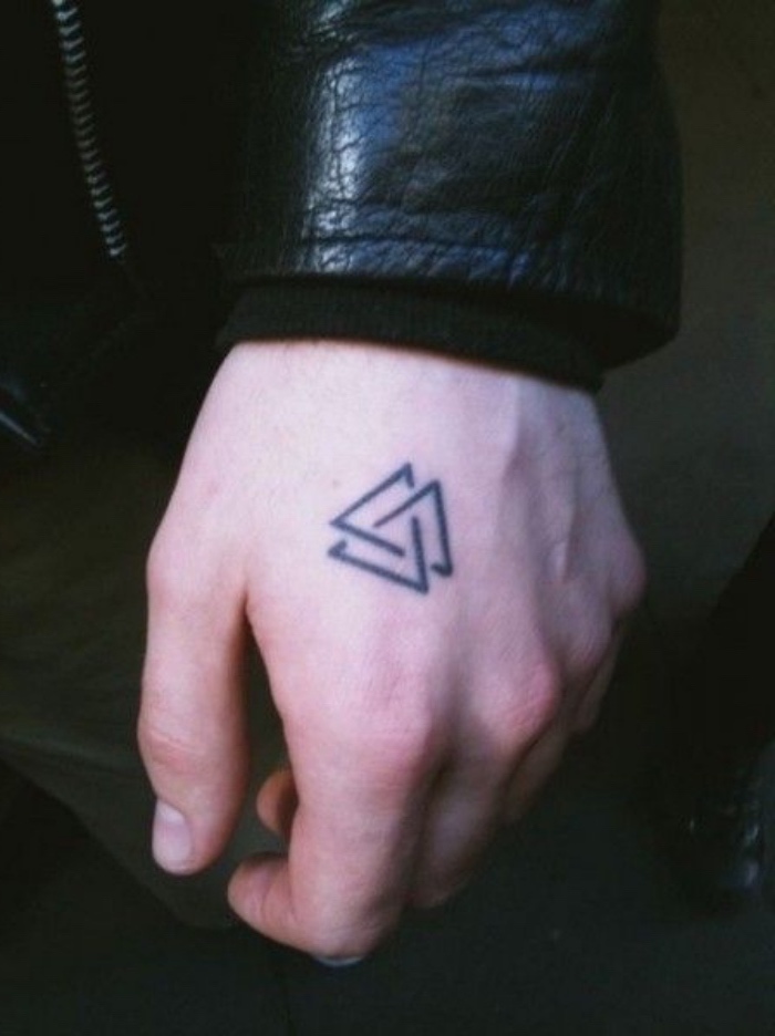Due triangoli come tatuaggio, tattoo sulla mano di un uomo