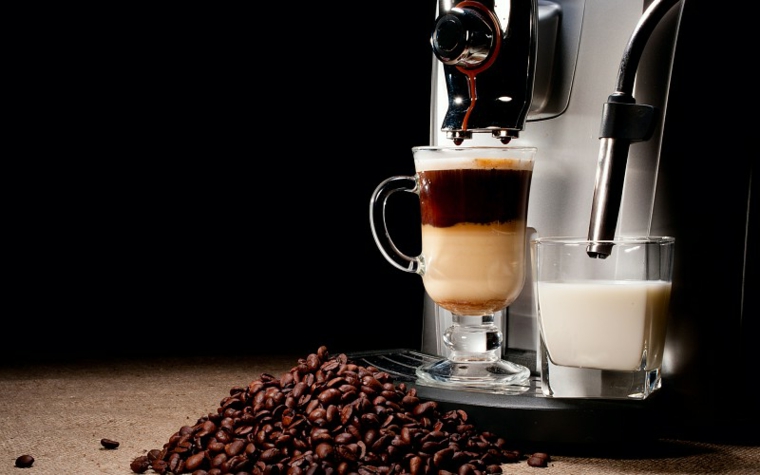 Caffè latte in tazza grande, macchina di caffè, chicchi di caffè