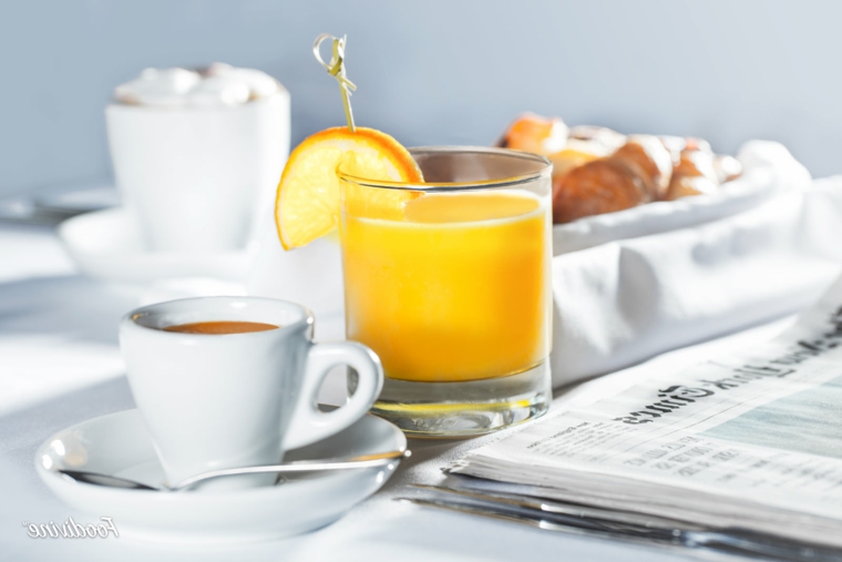 Bicchiere con succo di arancia, tazzina di caffè, foto di buongiorno